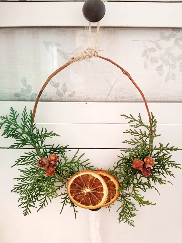 Corona  de Navidad con ramas de abeto y naranjas secas