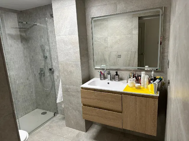 Reforma de baño con cerámica en tonos grises y lavabo suspendido de madera - 3