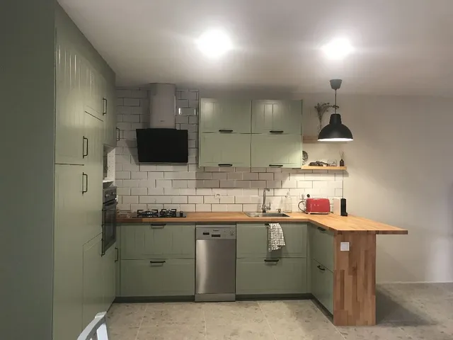 Una cocina moderna en tonos verdes tras la tirada de paredes