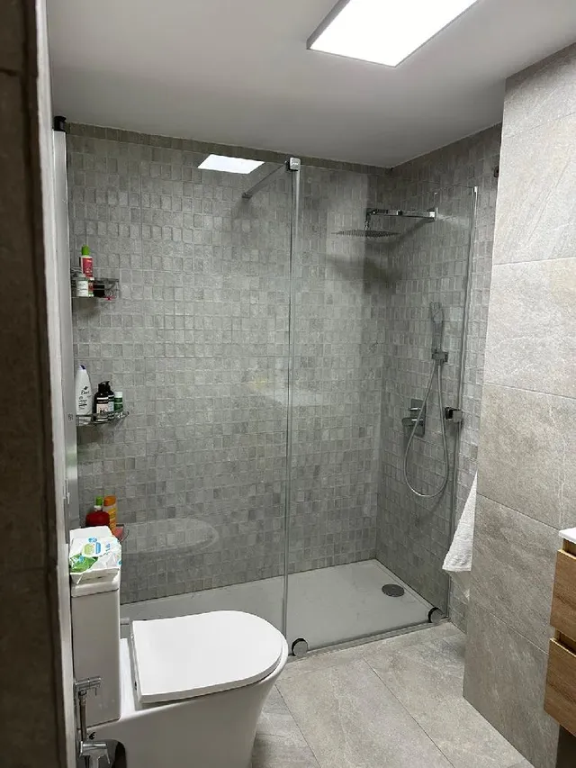 Reforma de baño con cerámica en tonos grises y lavabo suspendido de madera - 2