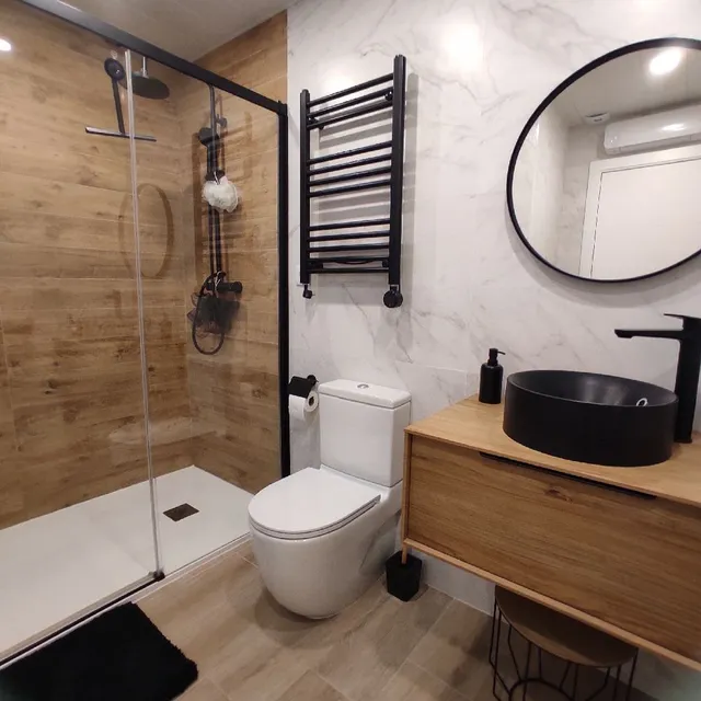 Reformando un baño antiguo con tonos negros, blancos y madera en el nuevo diseño