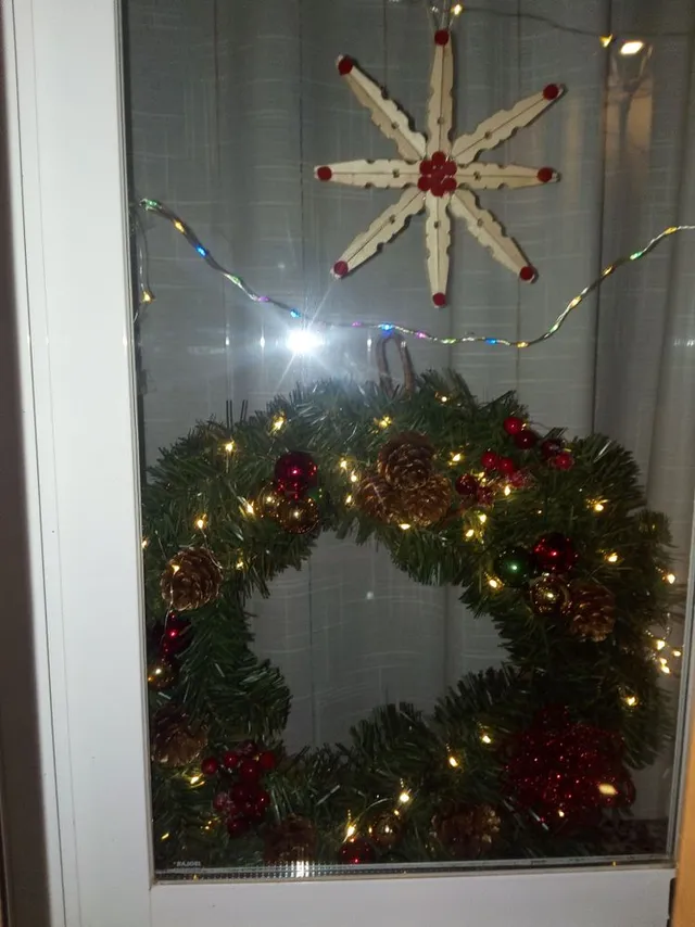 Decoración de ventana con guirnalda y otros elementos navideños