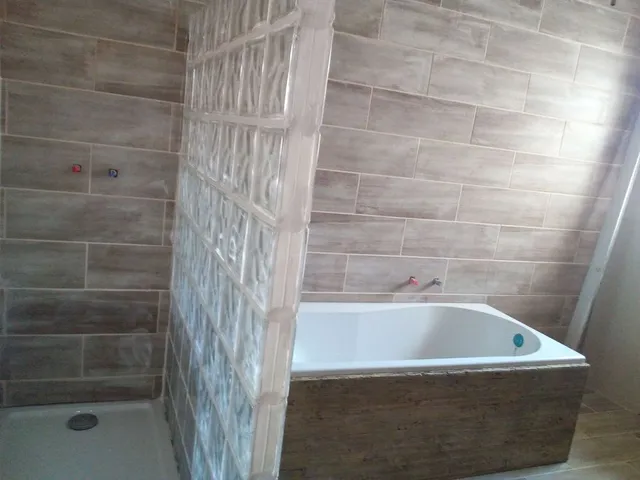 vista del plato de ducha, la madera que tapa la bañera, es una tabla de encofrar vieja, lijada y barnizada