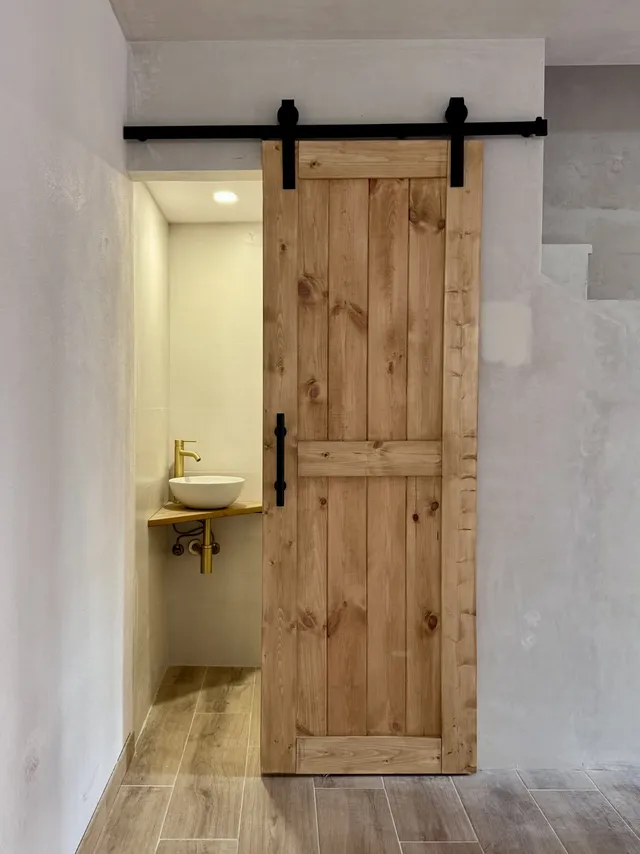 Instalación de una puerta corredera de granero para un aseo