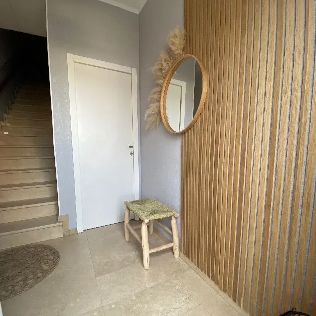 Actualización de la entrada de casa con paneles de madera y papel pintado
